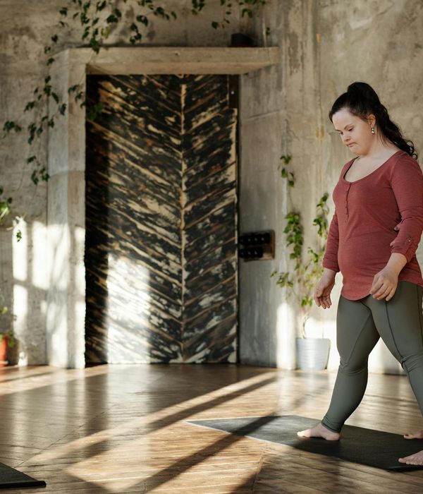 Person practicing gentle yoga movements in a dark room